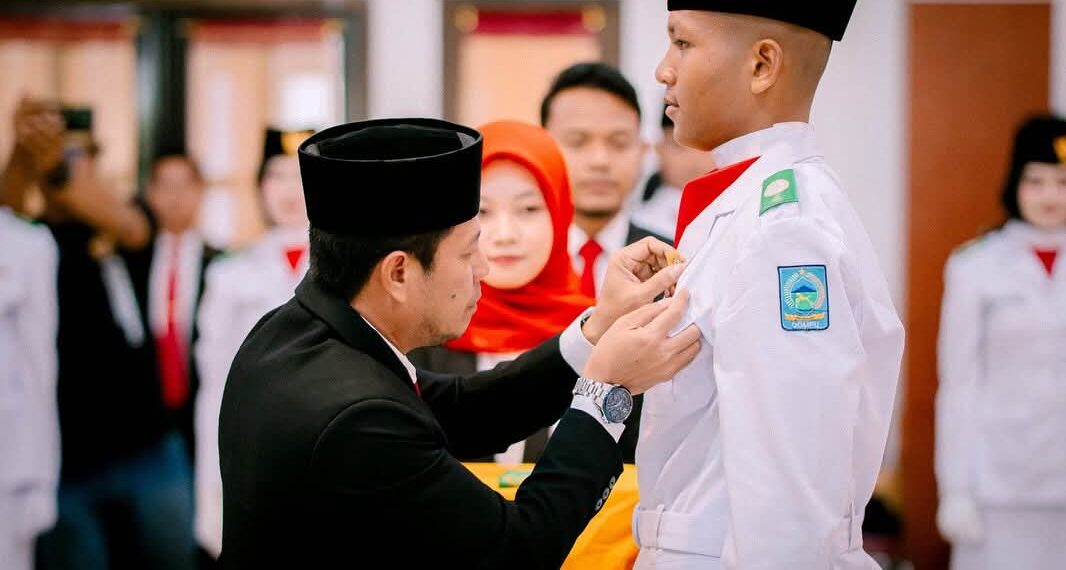 đź“· Pemasangan Kendit oleh Bupati Dompu kepada salah satu anggota Paskibra Dompu tahun 2025 saat acara pengukuhan Paskibra. (Prokopim).