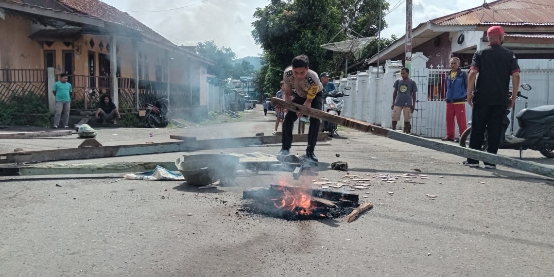 📷 Bhabinkamtibmas Kelurahan Potu membuka blokir jalan dan membersihkan sisa pembakaran ban bekas. (my).