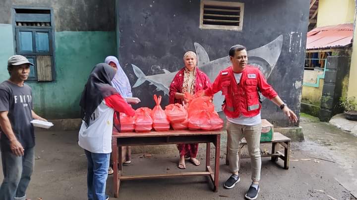 📷 Kurnia Ramadhan, SE.,ME (kanan/rompi merah) saat membagikan bantuan. (Kr).