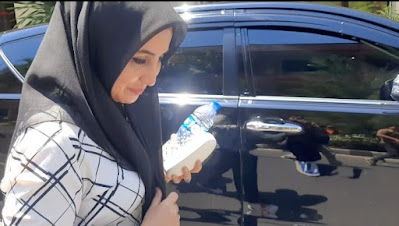 📷 Ellya berjalan menunduk ketika memasuki ruang pemeriksaan Mapolda NTB. (Aktualita.info).