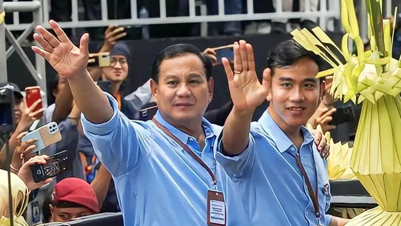 📷 Bersama Prabowo, Gibran tampil mengenakan kemeja warna biru muda lengan panjang. Tampak ia bersama Prabowo mengenakan lanyard coklatnya. (Liputan6.com).