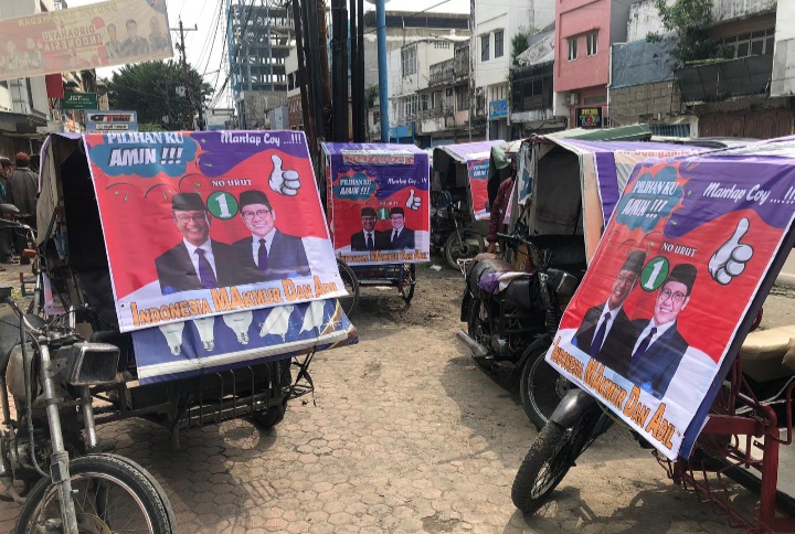 📷 Secara sukarela paguyuban abang becak di Medan, Sumatera Utara memasang spanduk sebagai bentuk dukungan terhadap pasangan AMIN di Pilpres 2024 tahun depan. (Au).
